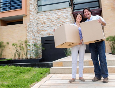 Professional movers carrying furniture through a residential property in Pimlico